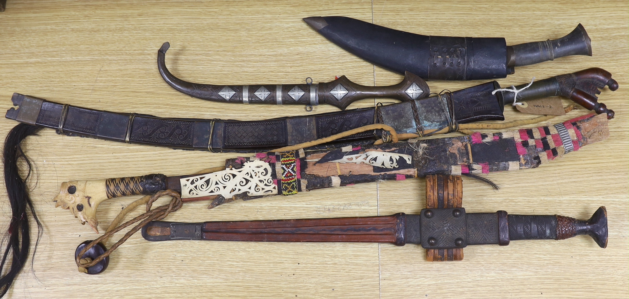 A group of assorted bladed weapons including a kukri, a jambiya, etc, longest 84cm